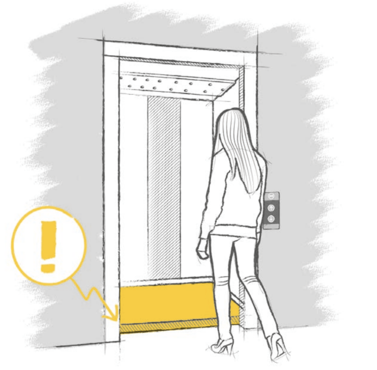 Une femme va rentrer dans un ascenseur où il y a un écart entre le sol de ce dernier et celui du sol de l'étage ou elle se trouve.